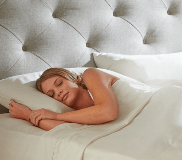 An attractive woman getting rejuvinating sleep on the Plush Beds Luxury Bliss mattress without being exposed to any of the toxic chemicals or fire retardants that are typically found in polyurethane mattresses.